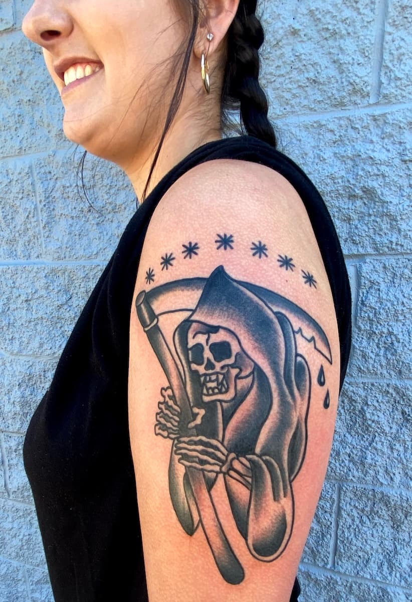 Tattoo of grim reaper on upper arm