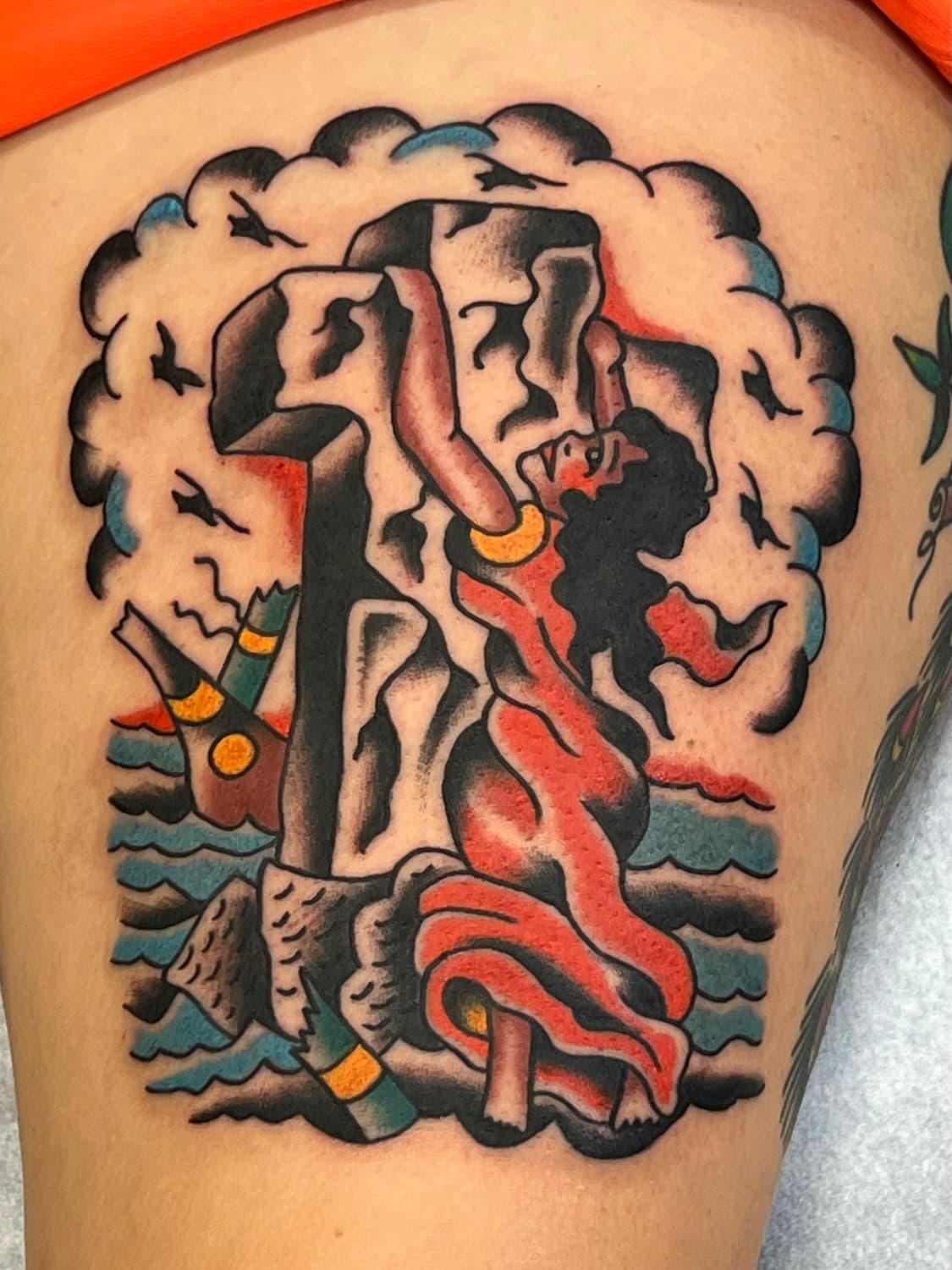 Tattoo of lady on a cross made from rock