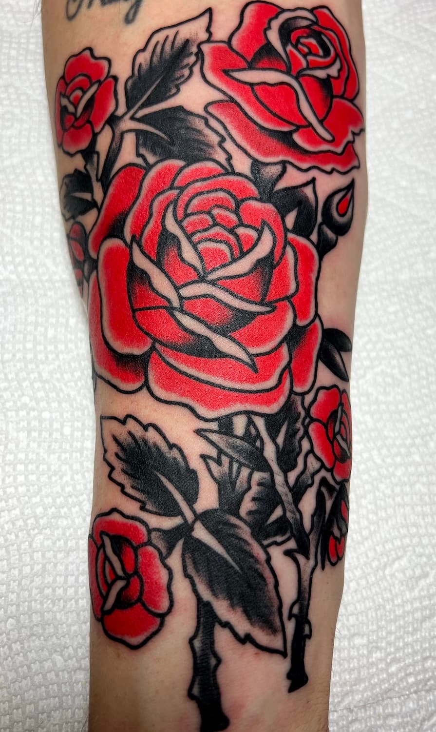 Tattoo of red roses on arm