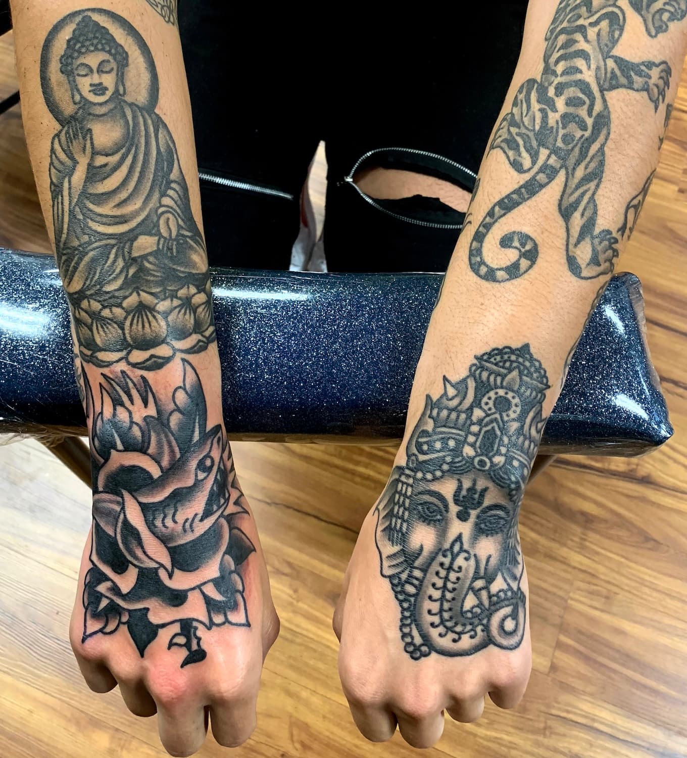 Tattoo of shark and rose on top of hand